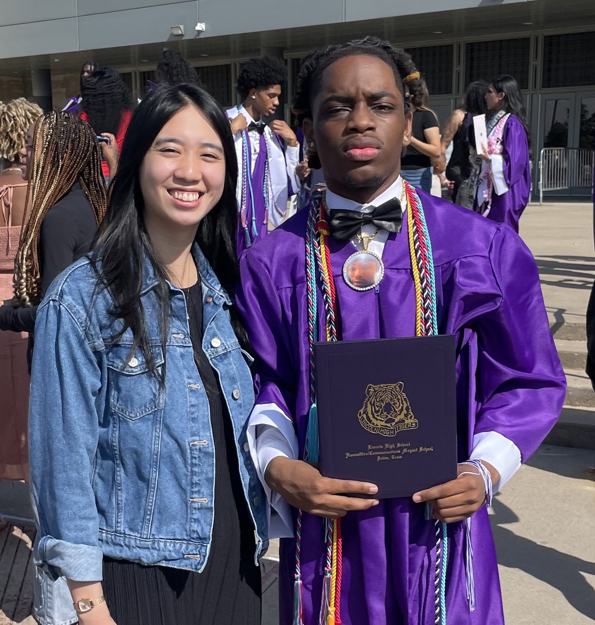 A graduate holding his diploma with his Life Coach on graduation day