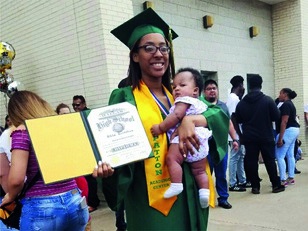 A graduate holding her diploma and her child